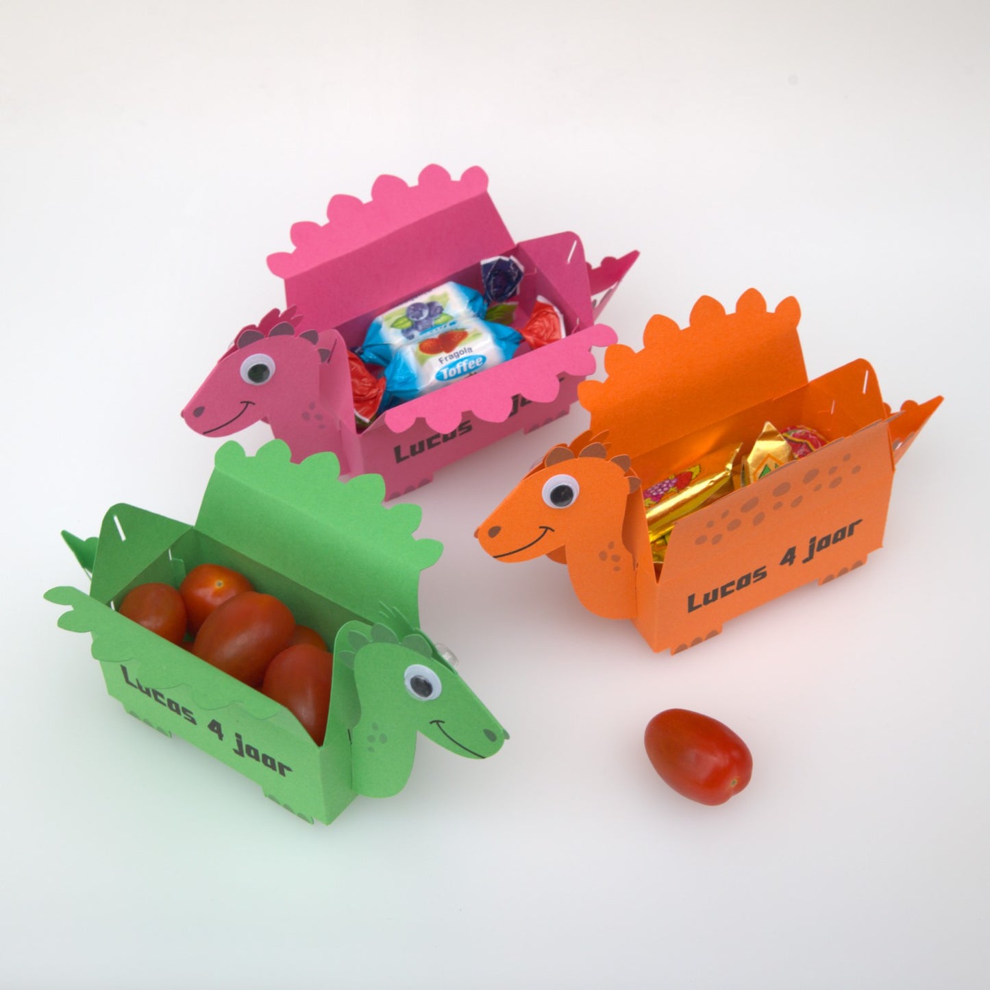 Drie dino traktatiedoosjes met snoeptomaatjes, toffee en ander snoep